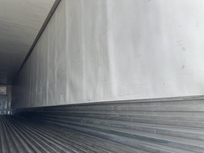Trailer side interior showing aluminum walls and ribbed floor of a reefer trailer, Utility 3000R branding not visible.