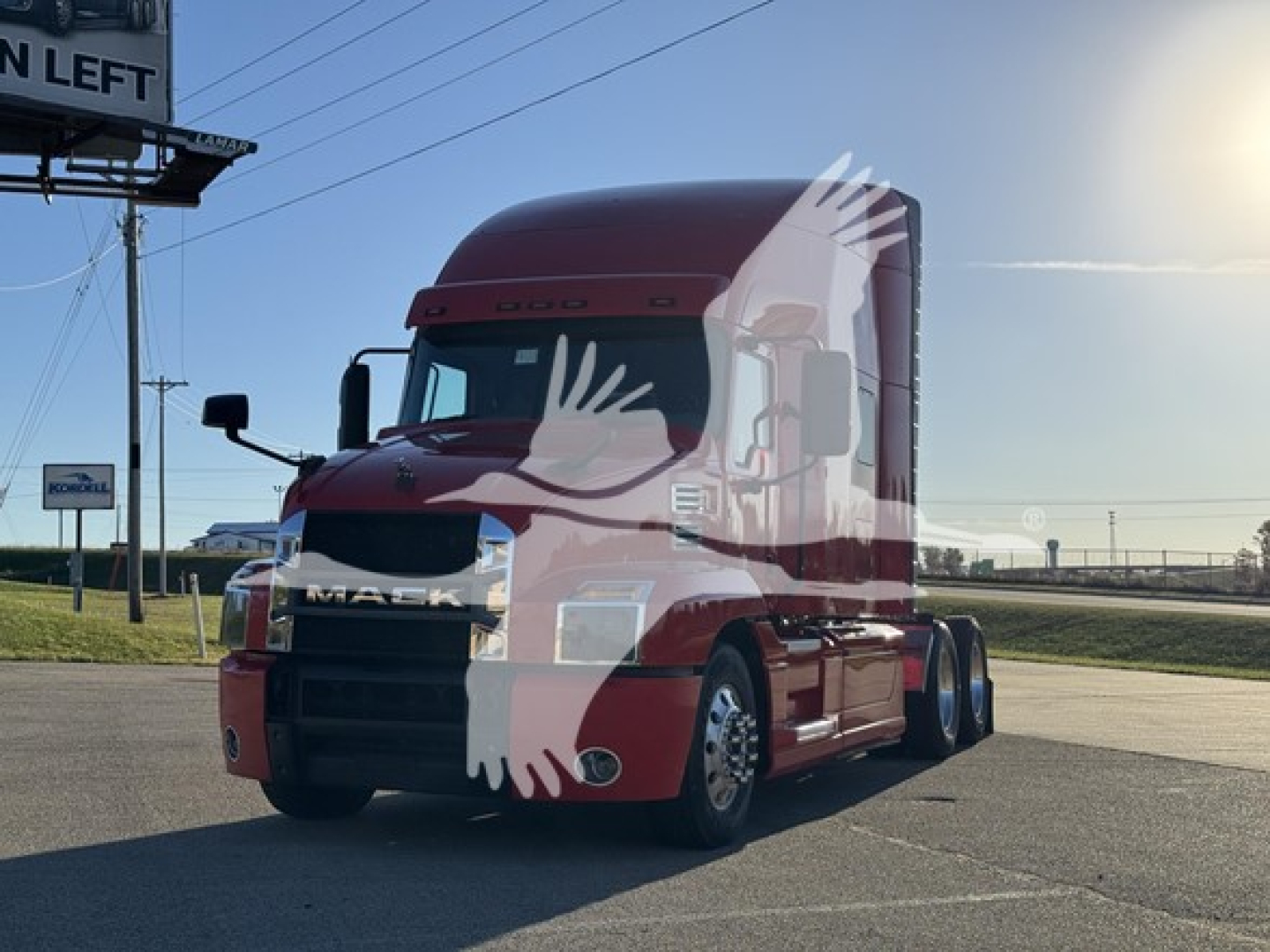 Mack Anthem 64T tractor truck in red, front-left view showing cab and grille, with emblem and headlights visible.