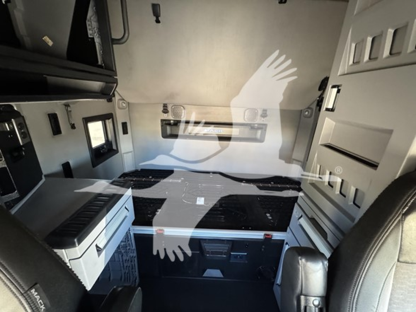 Interior of a 2019 Mack Anthem 64T sleeper cab showing side storage cabinets, a floor cooler, and grey/black color scheme.
