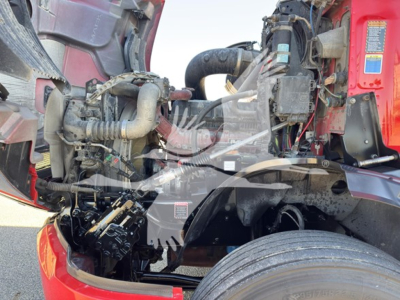 Truck engine bay and front axle of a 2019 Mack Anthem 64T showing exposed engine components, wiring, hoses, and steering area.