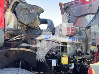 Mack Anthem 64T engine bay showing air filter housing, hoses, yellow oil filter canister, and various engine components.