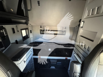 Interior of a 2019 Mack Anthem 64T sleeper cab showing side storage cabinets, a floor cooler, and grey/black color scheme.