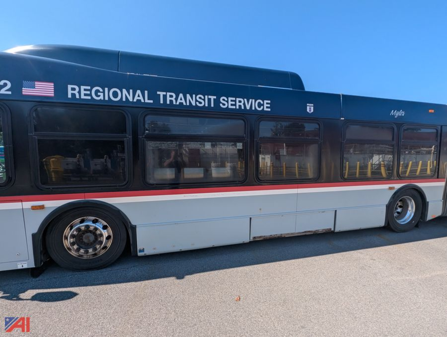 Bus side view showing Regional Transit Service lettering on a blue and white New Flyer XD60 transit bus with windows and single red stripe.