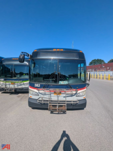 Front view of a 2013 New Flyer XD60 transit bus with yellow handrails, large windshield, and a metal a-frame bumper at the front.