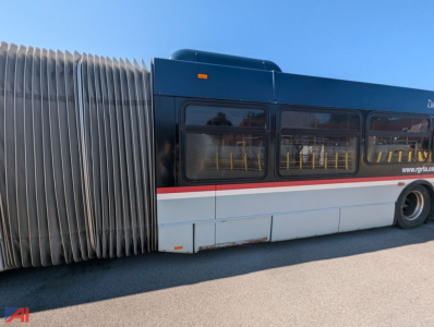 Bus side view showing New Flyer XD60 transit bus with accordion walkway near door and blue exterior.