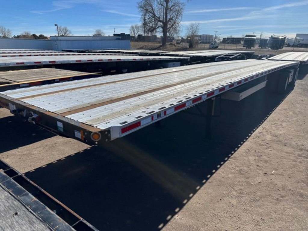 Flatbed trailer bed showing aluminum deck with reflective safety tape and side rails, 2019 Fontaine Infinity 48' Combo Flatbed, used.
