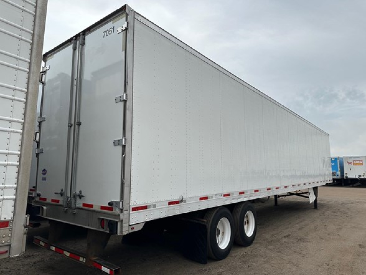 Utility 4000Dx trailer in side view showing tandem axle to rear with white exterior and rear doors.