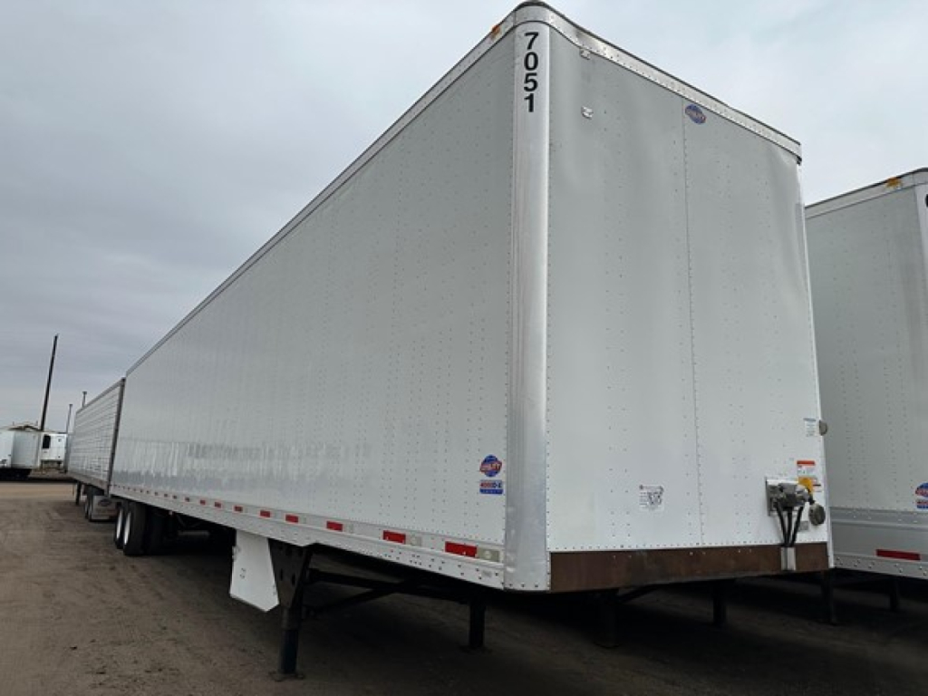 Utility 4000Dx trailer in a lot, white aluminum cargo with rear doors, side markings, and black tandems visible.