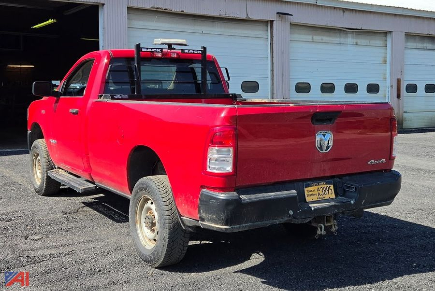 Ram 2500 Tradesman pickup truck with plow, red long bed, rear view showing tailgate and hitch, New York plate, in a lot.