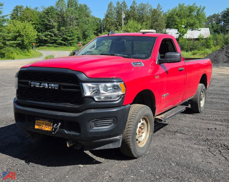 Red 2020 Ram 2500 Tradesman pickup truck with plow in a rural lot.