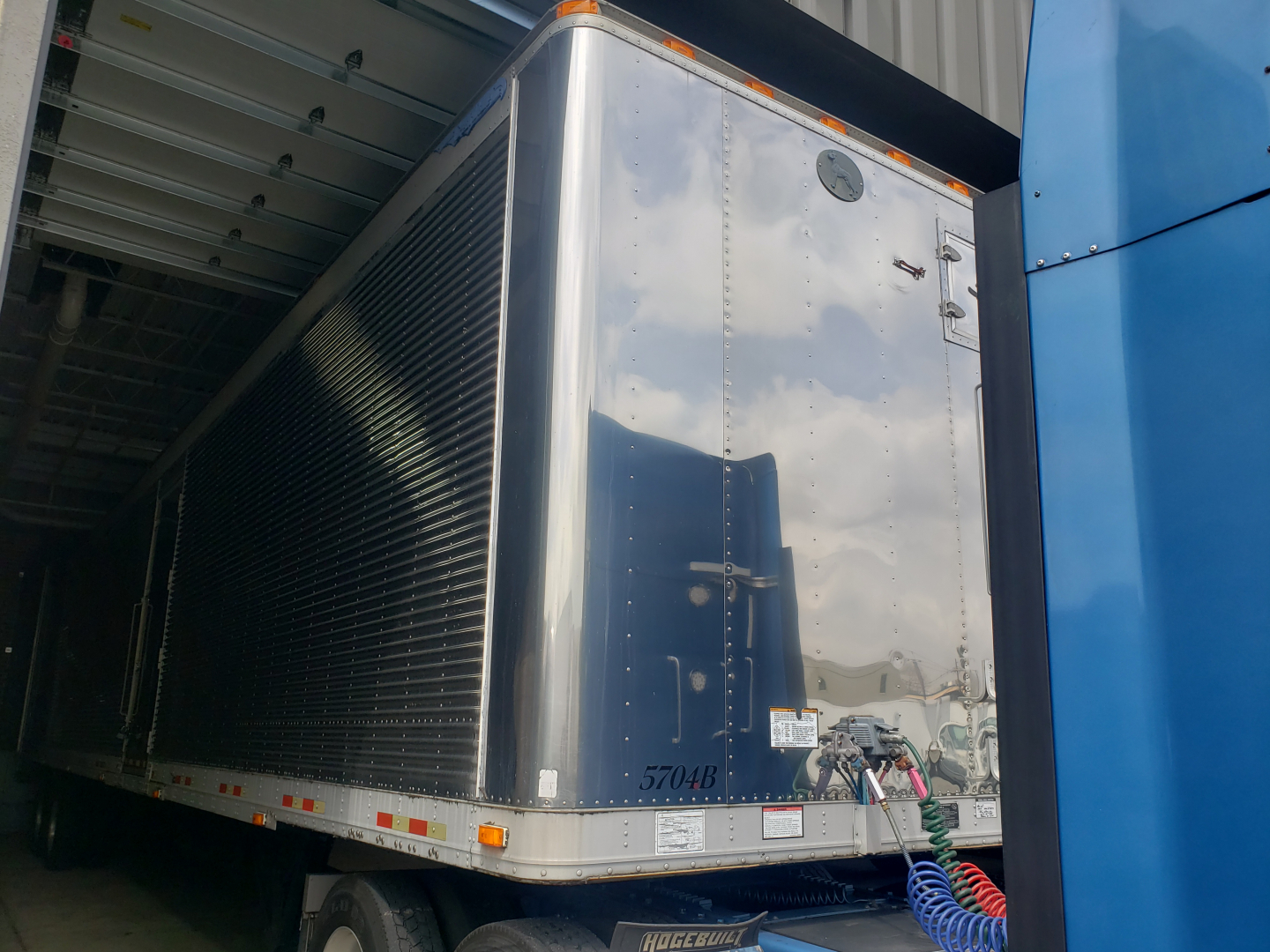Great Dane 53' dry van trailer interior with insulated walls and rear door area, reflecting light on polished exterior.