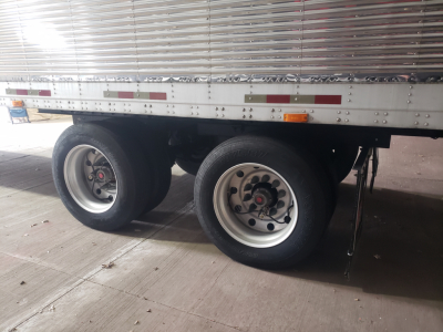 Great Dane 53' dry van trailer tandem axles showing wheels and side rails with reflective tape and corrugated aluminum walls.