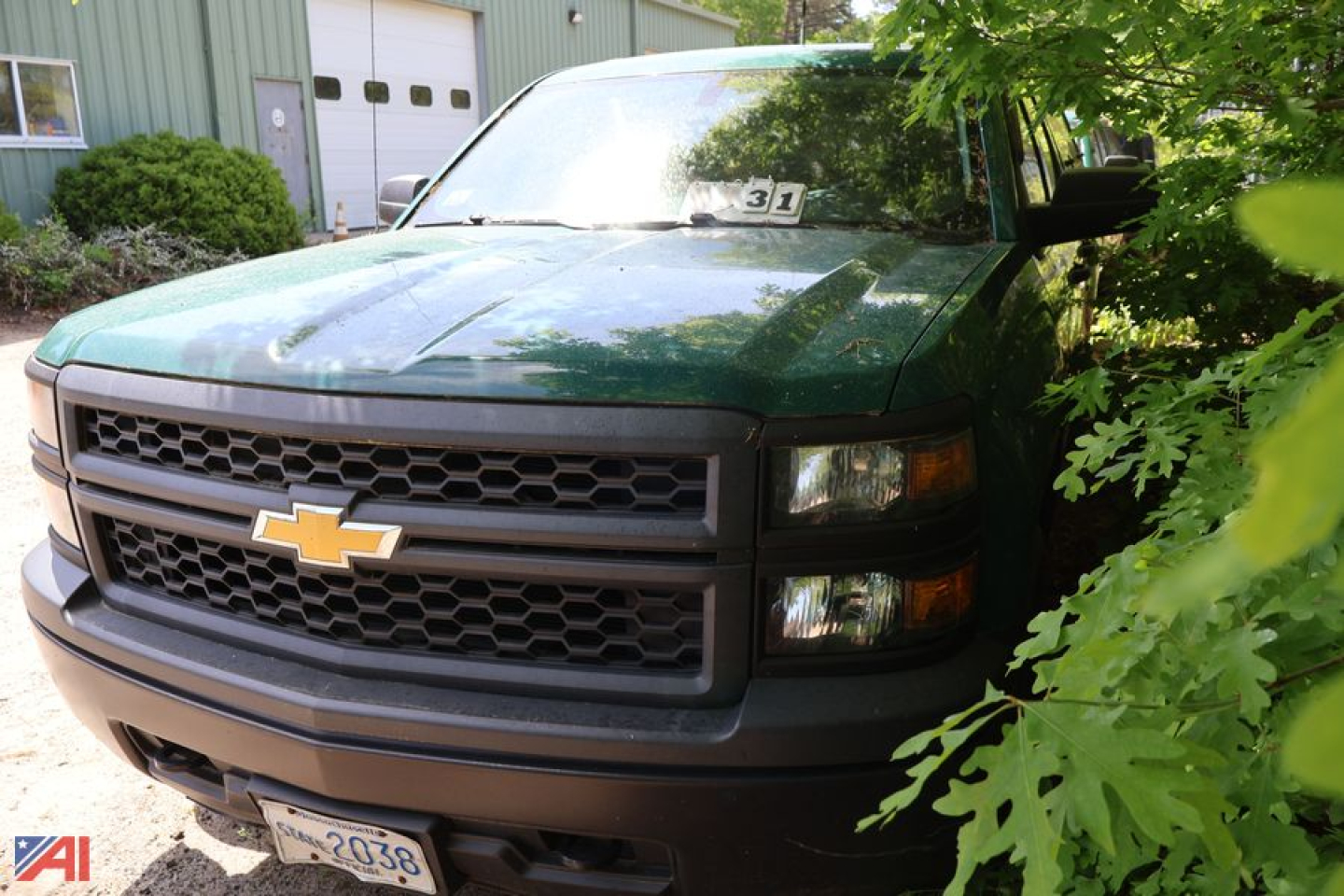 Chevrolet Silverado 1500 Crew Cab pickup with cap, front grille visible, Dark green/black color, Chevrolet bowtie emblem, 2011-2015 era design.