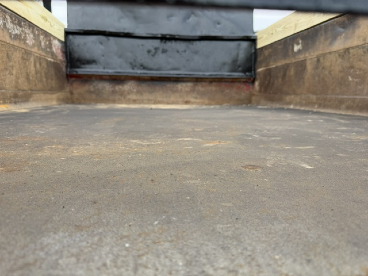 Truck bed interior of a 2006 Ford F750 SD dump truck showing metal side walls and a textured loading surface.