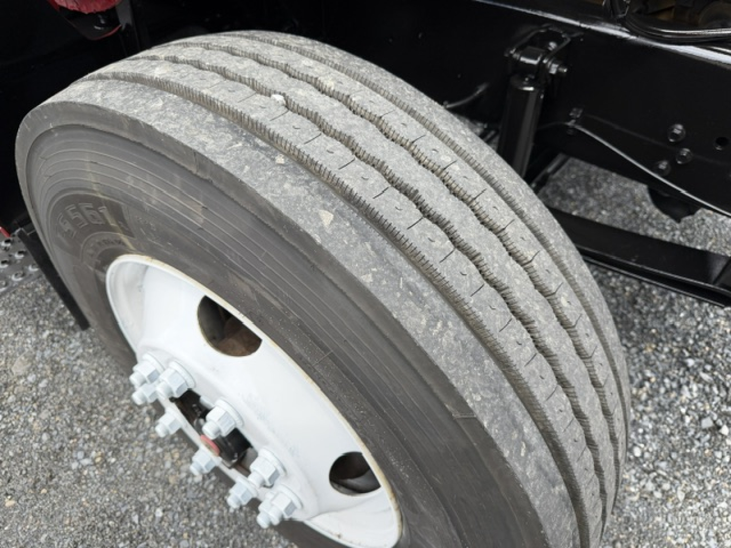 Ford F750 SD wheel showing tire and white wheel hub with lug nuts