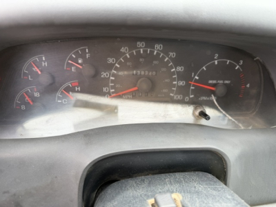 Dashboard view of a 2006 Ford F750 SD displaying gauges including speedometer, fuel, temperature, and tachometer with odometer reading 138,340 miles.