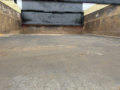 Truck bed interior of a 2006 Ford F750 SD dump truck showing metal side walls and a textured loading surface.