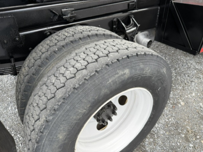 Dual rear tires on a Ford F-750 SD dump truck chassis with white steel wheel and black frame visible.