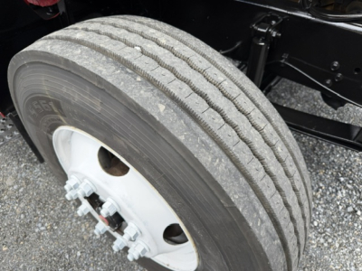 Ford F750 SD wheel showing tire and white wheel hub with lug nuts