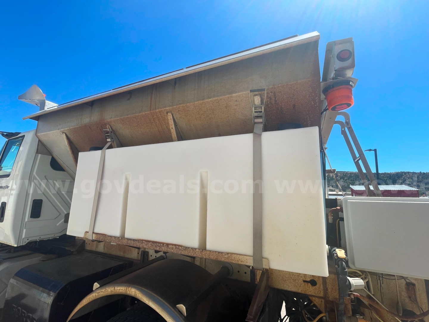 Dump truck bed of a 2012 International 7400 with raised dump body and hydraulic system visible.