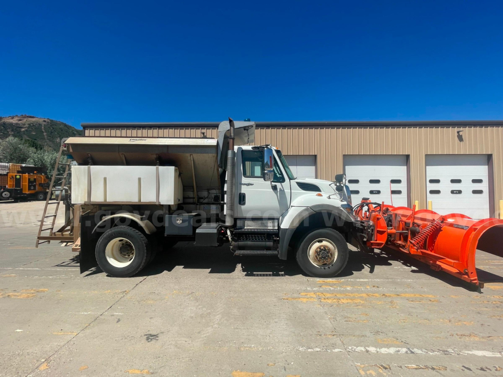 Truck side view showing 2012 International 7400 dump truck with snow plow attachment, VIN 1HTWEAAR9CJ625870, stock 2671-356, tag labels on cab and equipment.