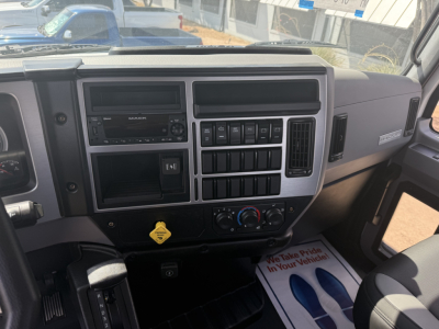 Dashboard of a 2026 Mack MD6 truck cab showing instrument panel, controls, climate dials, radio, and cup holder area.