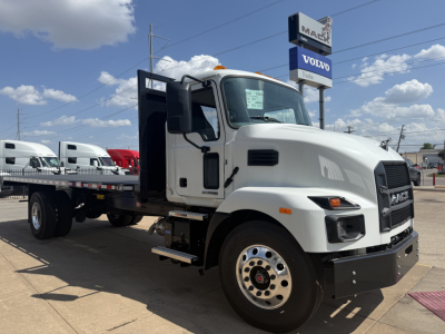 Mack MD6 flatbed truck in a dealership lot, front-right view, white cab, flatbed with black rails, VIN sticker visible through windshield; stock number 68812.