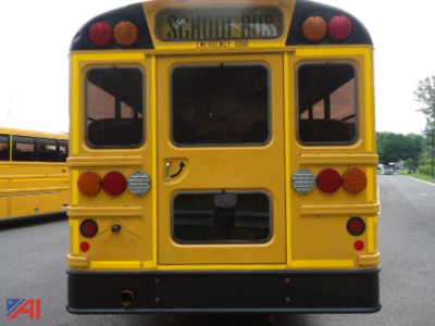 School bus rear view showing CE Series, yellow BUS with taillights and School Bus sign, used condition.