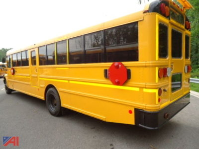 2011 IC Corporation CE Series school bus, rear and side views in yellow with black windows, stop signs extended, school bus lights visible.