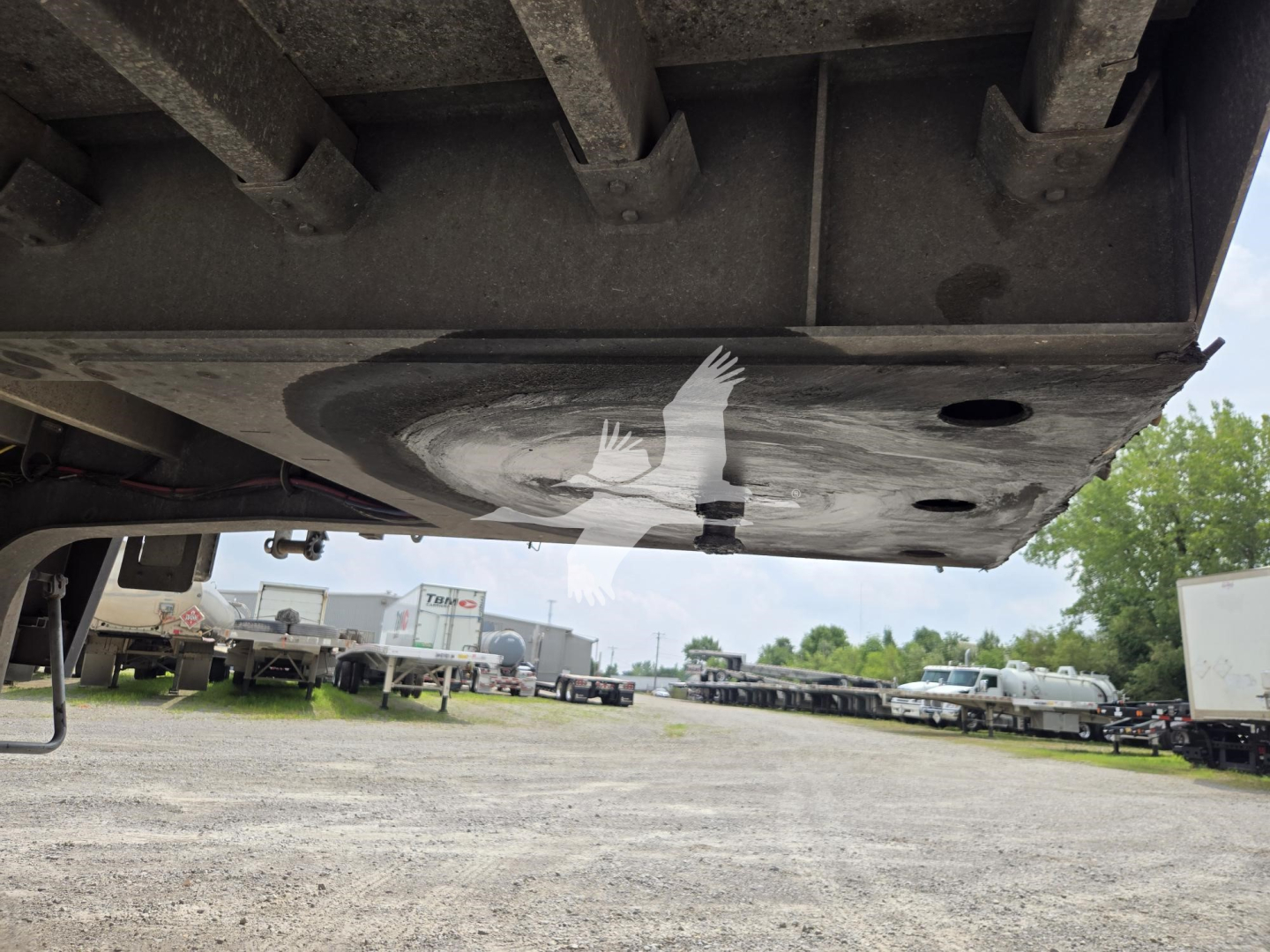 Bottom view of a Wabash drop deck trailer showing the underside and deck surface with circular cutouts and structural beams.