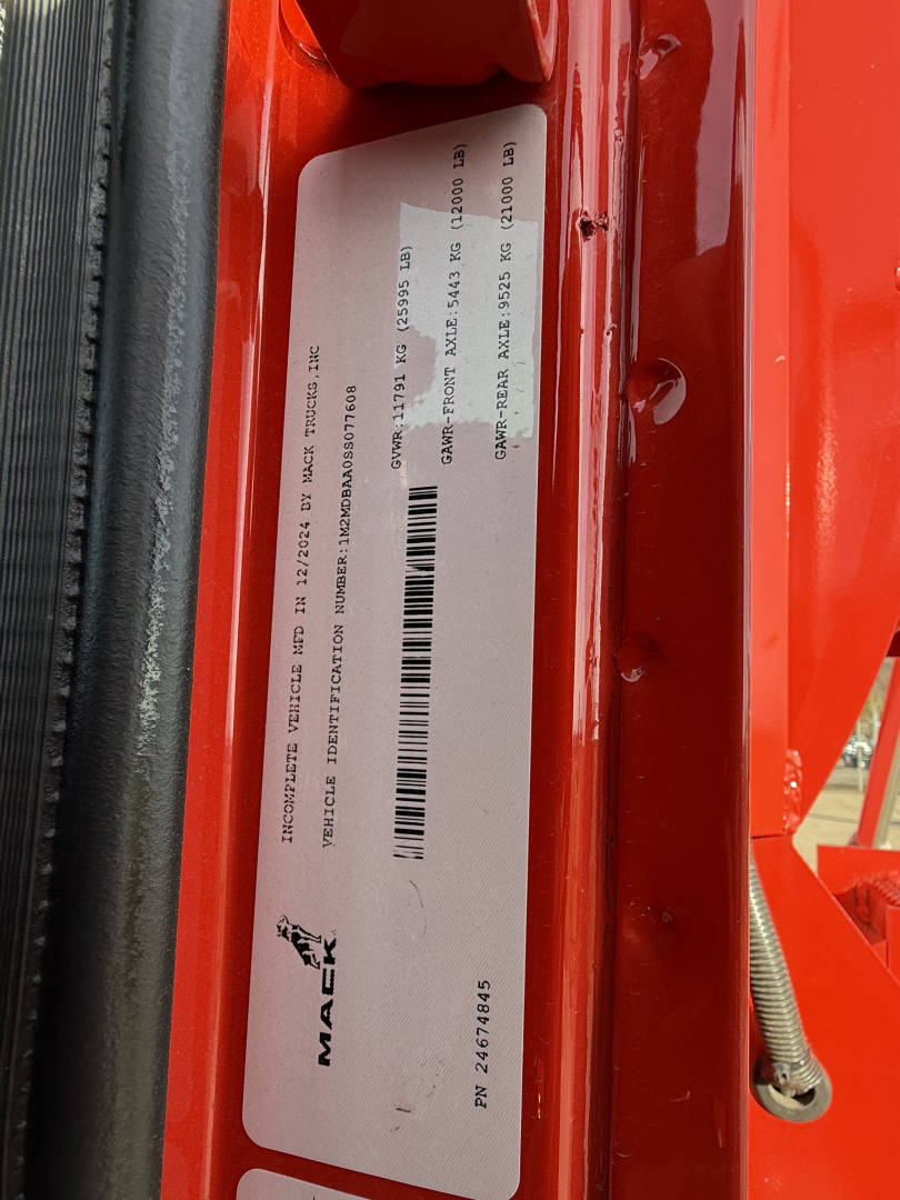 Mack MD7 truck showing vehicle identification label with VIN and barcodes on door jamb.