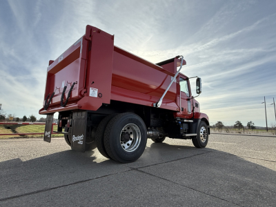 Mack MD7 dump truck in red, rear and passenger side visible, dump bed raised slightly, chrome mirrors, black wheels, side step, VIN badge area not legible.