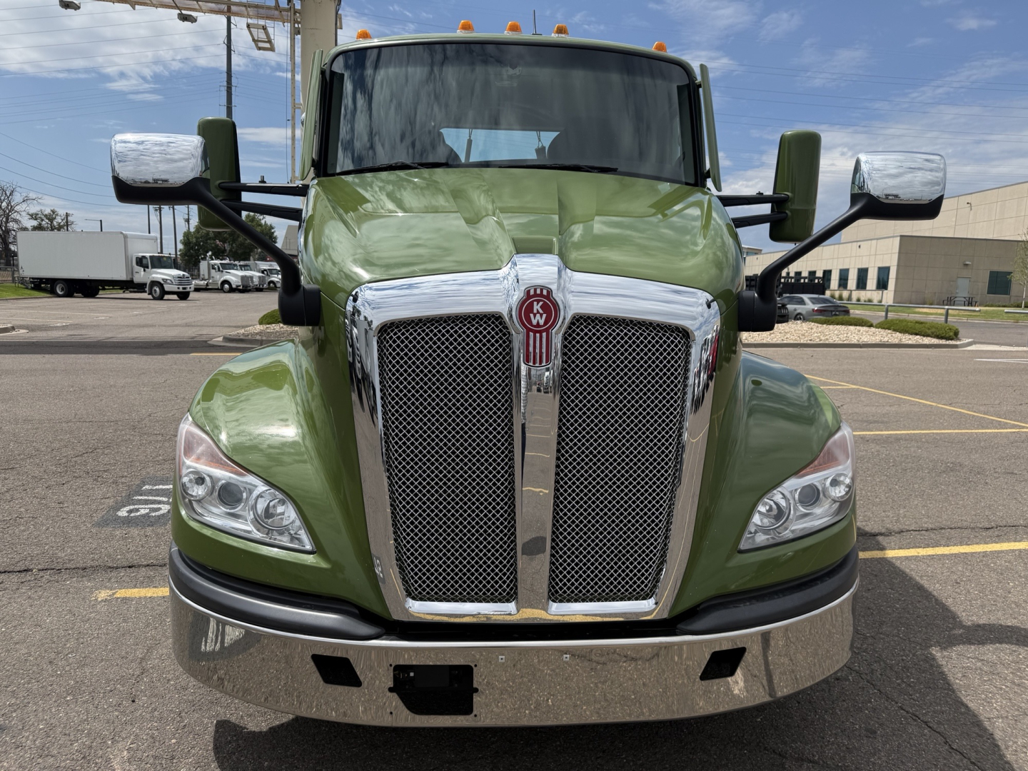 Kenworth T680 front view showing green cab, chrome grille, and large side mirrors. Headlights visible, stock number 0628638 on lot.