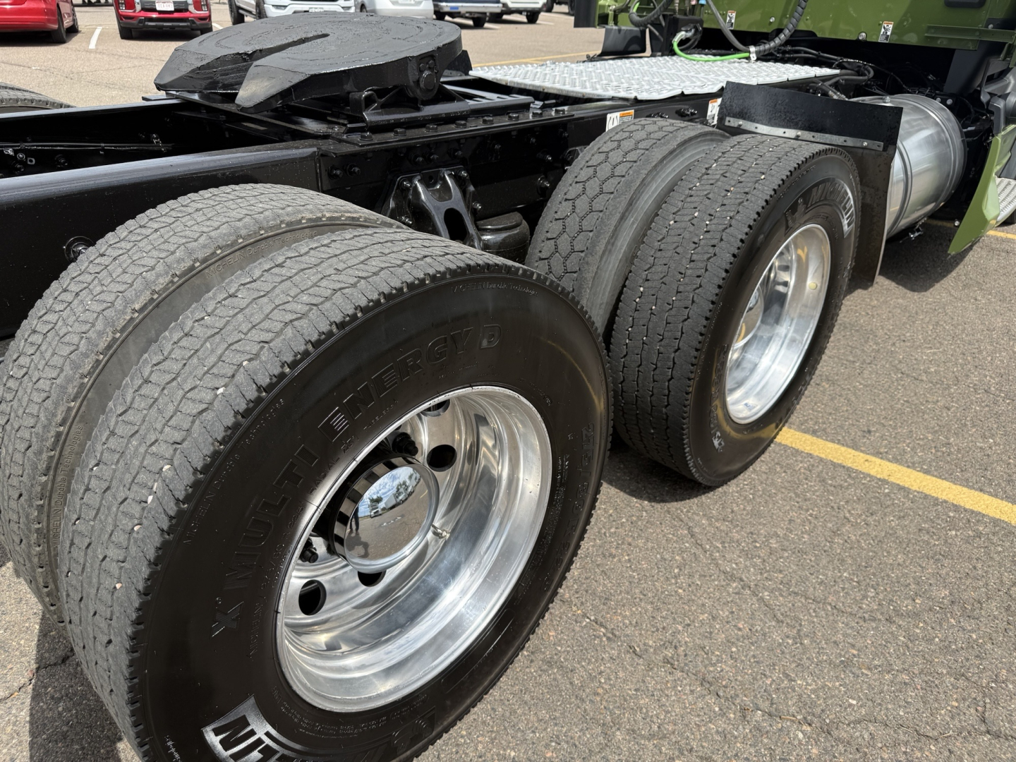 Kenworth T680 truck rear dual axle wheels and frame showing tires and chrome rims.