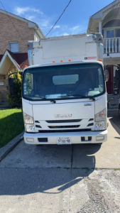 Isuzu NRR box truck front view showing cab and box in daylight.