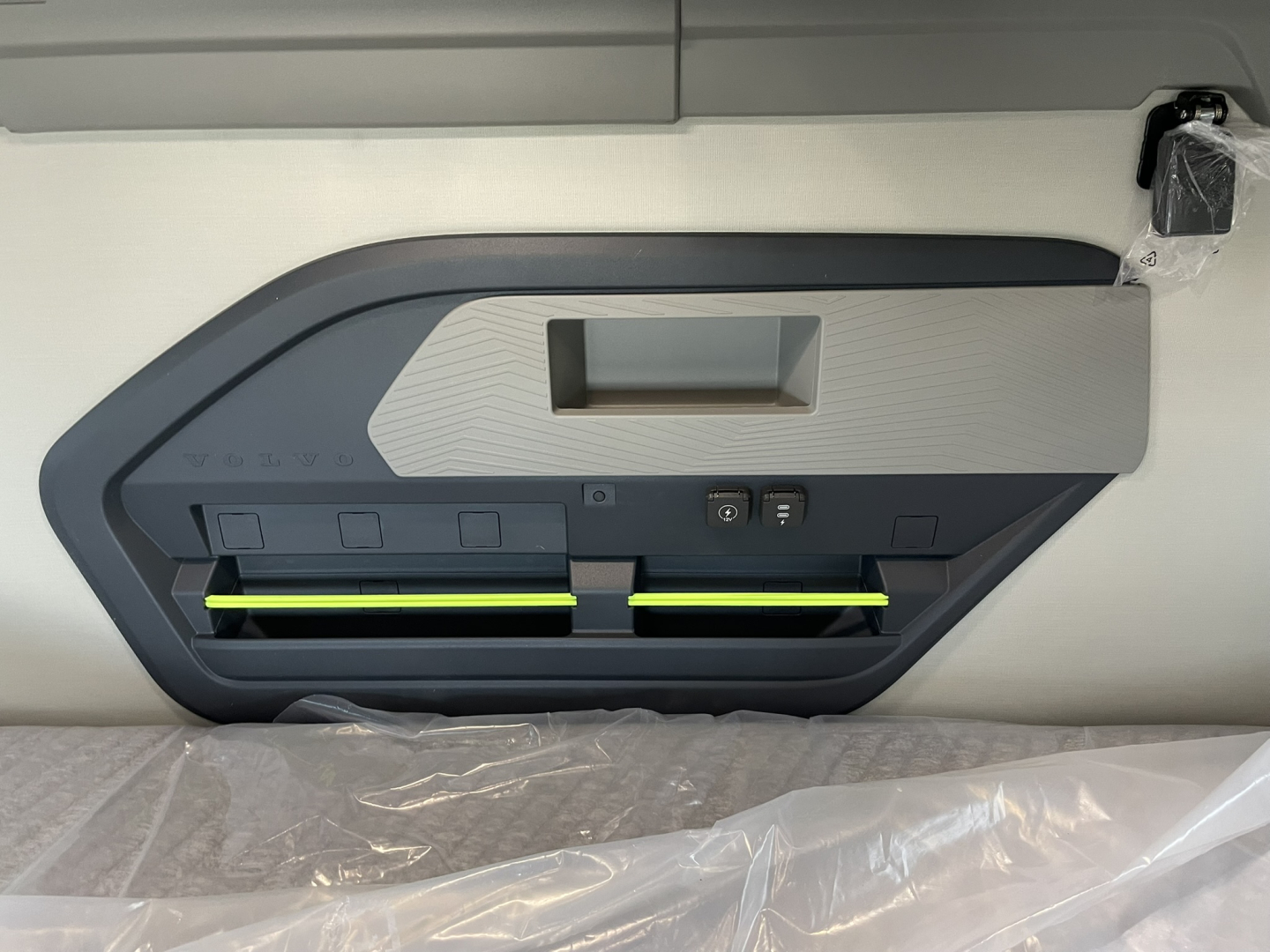 Volvo VNL cab interior panel showing storage/recessed handle and illuminated yellow-green rails inside a sleeper door panel.