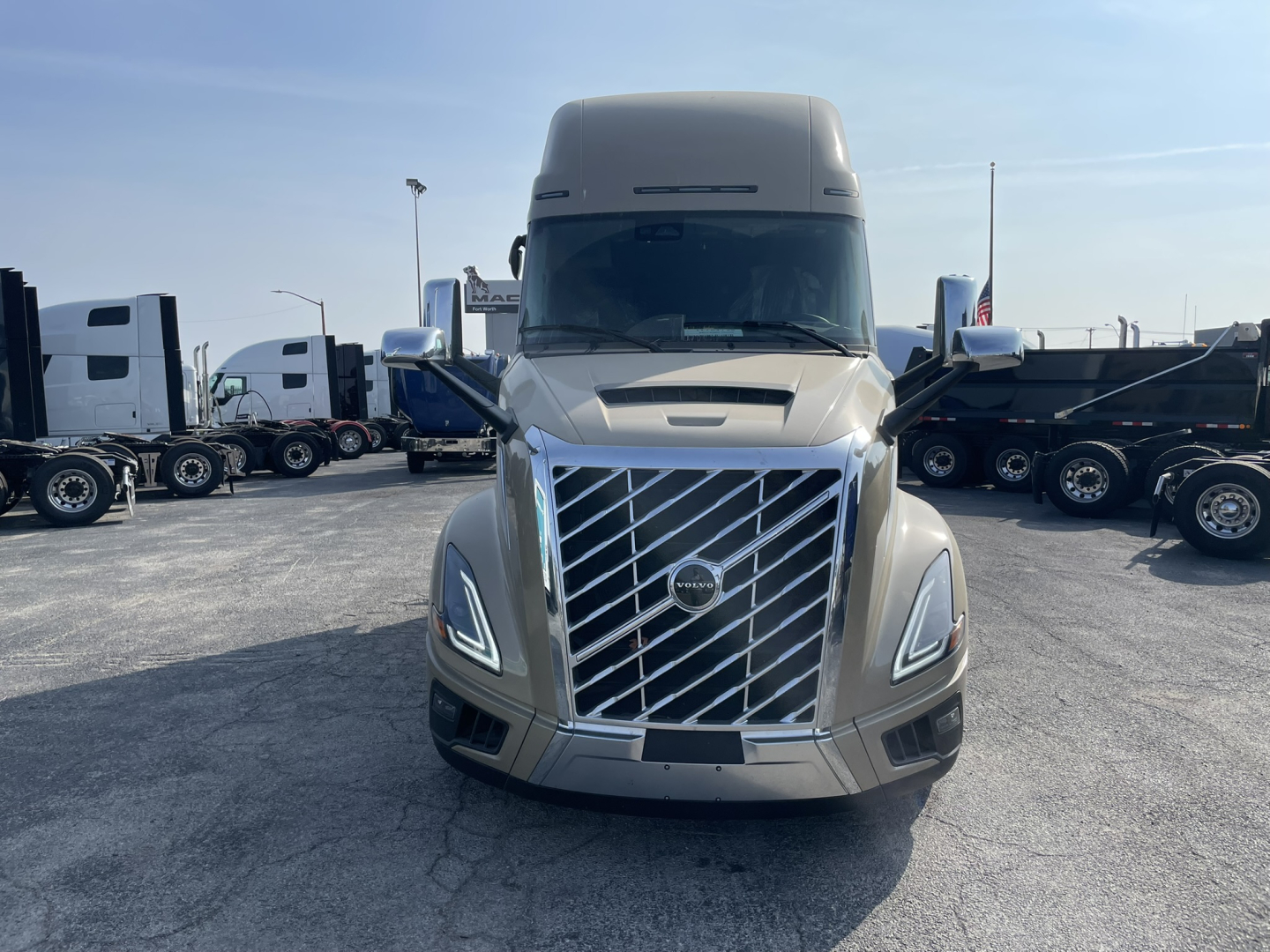 Front view of a 2026 Volvo VNL64T860 sleeper cab truck showing chrome grille, Volvo emblem, daytime running lights, and side mirrors.