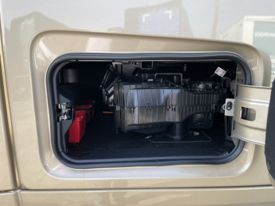 Truck fuel/air system compartment view showing battery red case and black plastic intake/airbox in a Volvo VNL64T860 engine bay side door access