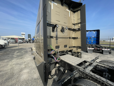 Volvo VNL64T860 truck rear with open sleeper cab door showing wiring and chassis components at tail, storage area, and wiring harness visible.