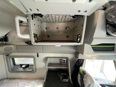 Volvo VNL truck sleeper cab storage cabinet open with interior metal panels and mounting brackets visible.