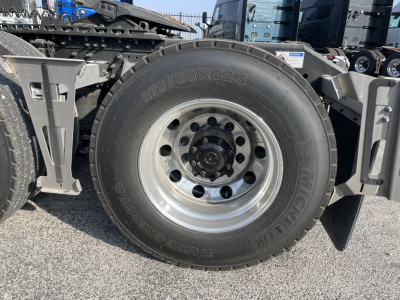 Volvo VNL64T860 tractor wheel with tire and rim, side view showing wheel hub and suspension components.