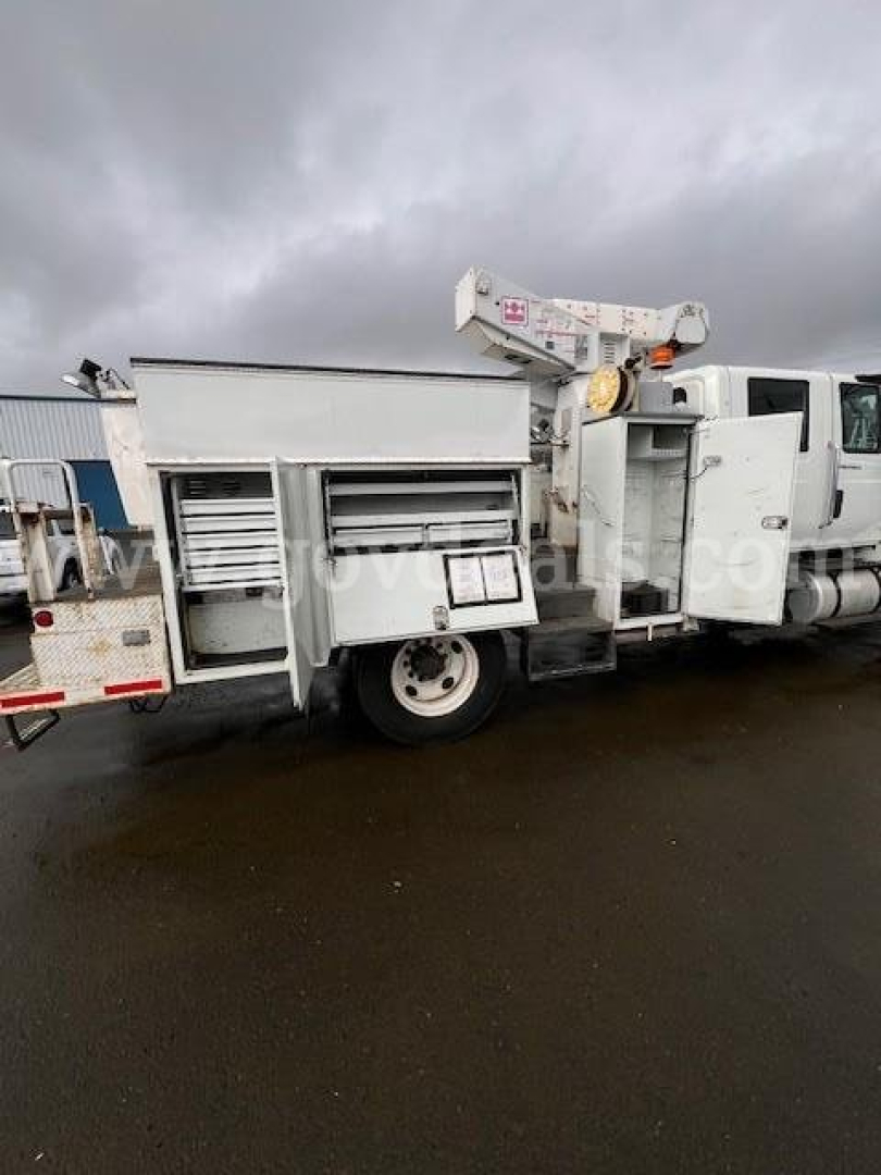 Truck body with utility compartments and mounted crane showing side view of an International 7400 utility truck.