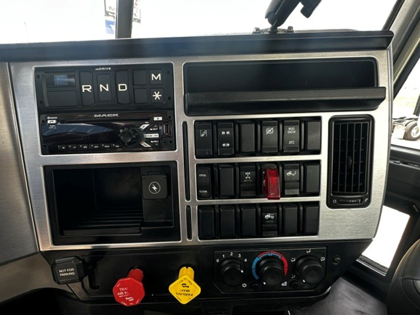 Dashboard panel of a 2019 Mack Anthem daycab truck showing gear selector (R N D M), radio, multiple switches, climate controls, and warning indicators.