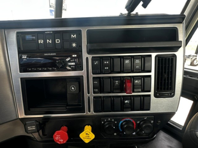 Dashboard panel of a 2019 Mack Anthem daycab truck showing gear selector (R N D M), radio, multiple switches, climate controls, and warning indicators.