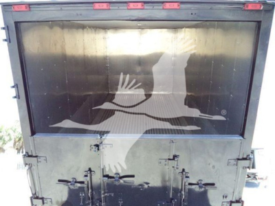 Truck rear view showing metal truck bed with tailgate latches and reflective surface.