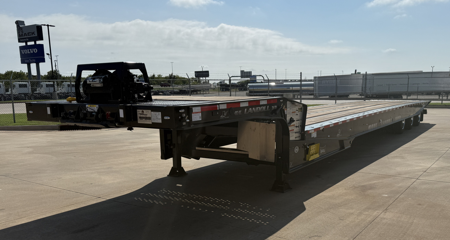 Traveling 55-ton lowboy trailer with extendable deck in serviceable condition. Long low-profile trailer with landing legs and gooseneck hitch.