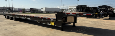Lowboy trailer showing Landoll 455B-53 55 Ton traveling axle with long black frame and gooseneck visible.