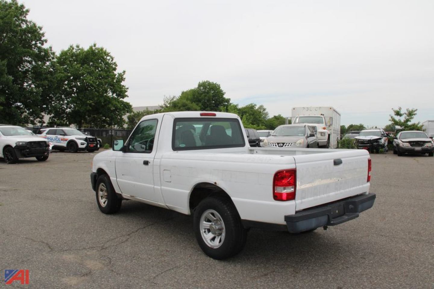 2006 Ford Ranger pickup truck in a used vehicle lot, white extended cab with short bed, rear three-quarter view.