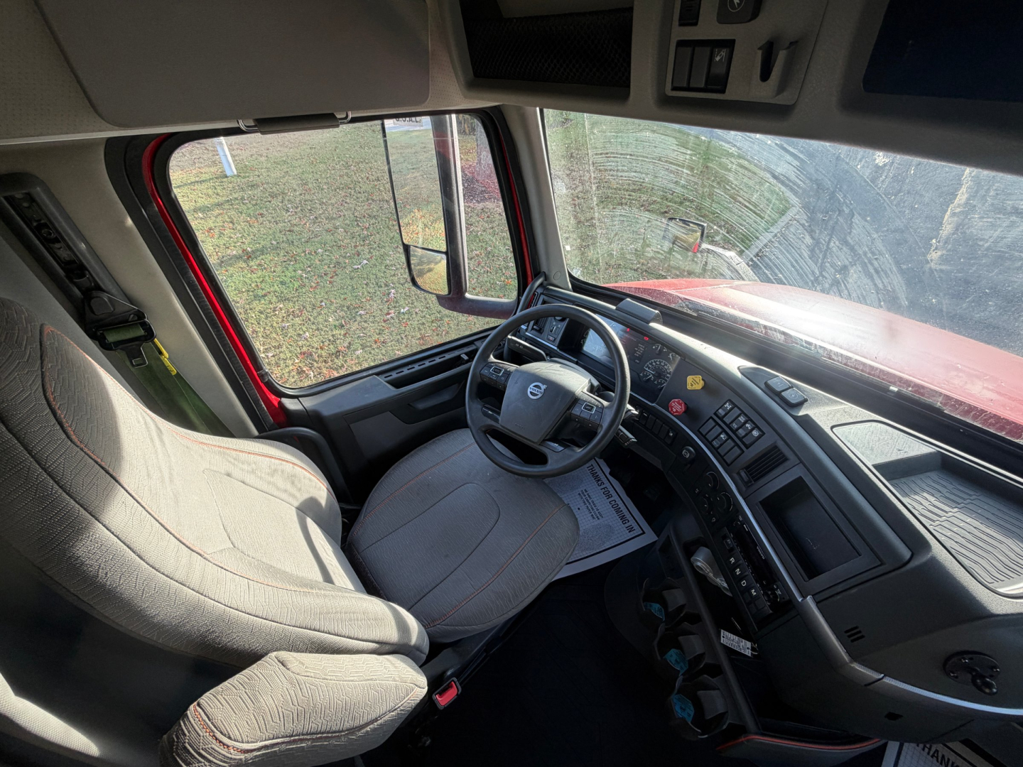 Volvo VNL64T760 truck cab interior showing driver seat, steering wheel, dashboard, and side window