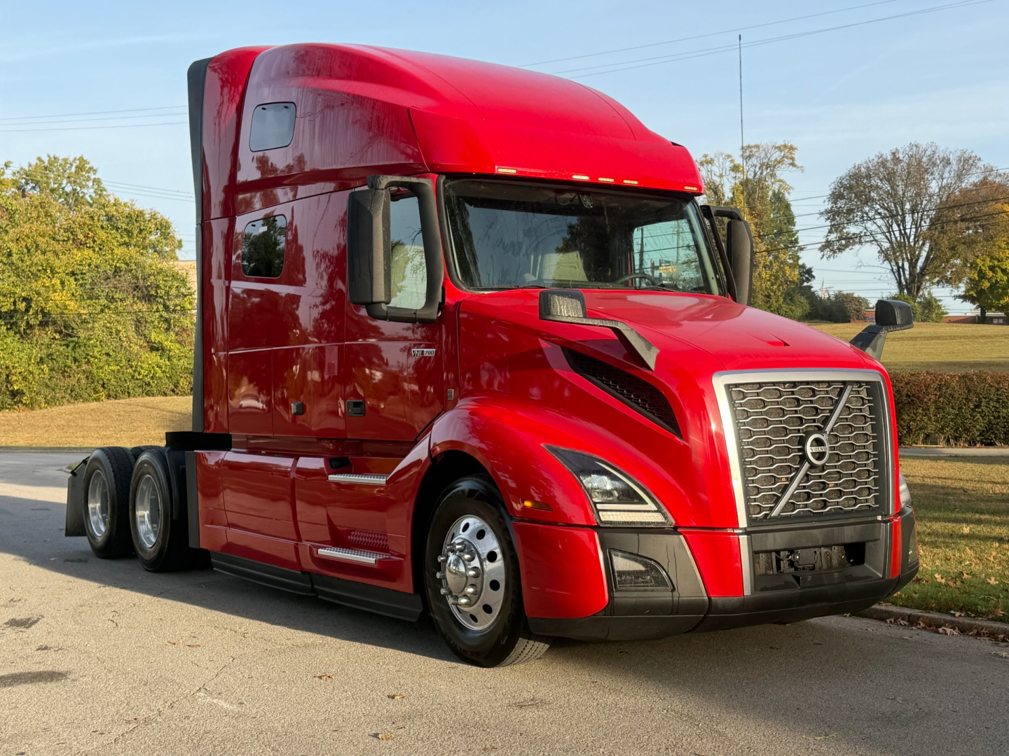 Volvo VNL64T760 tractor cab side view showing red paint and grille, no visible text or labels.
